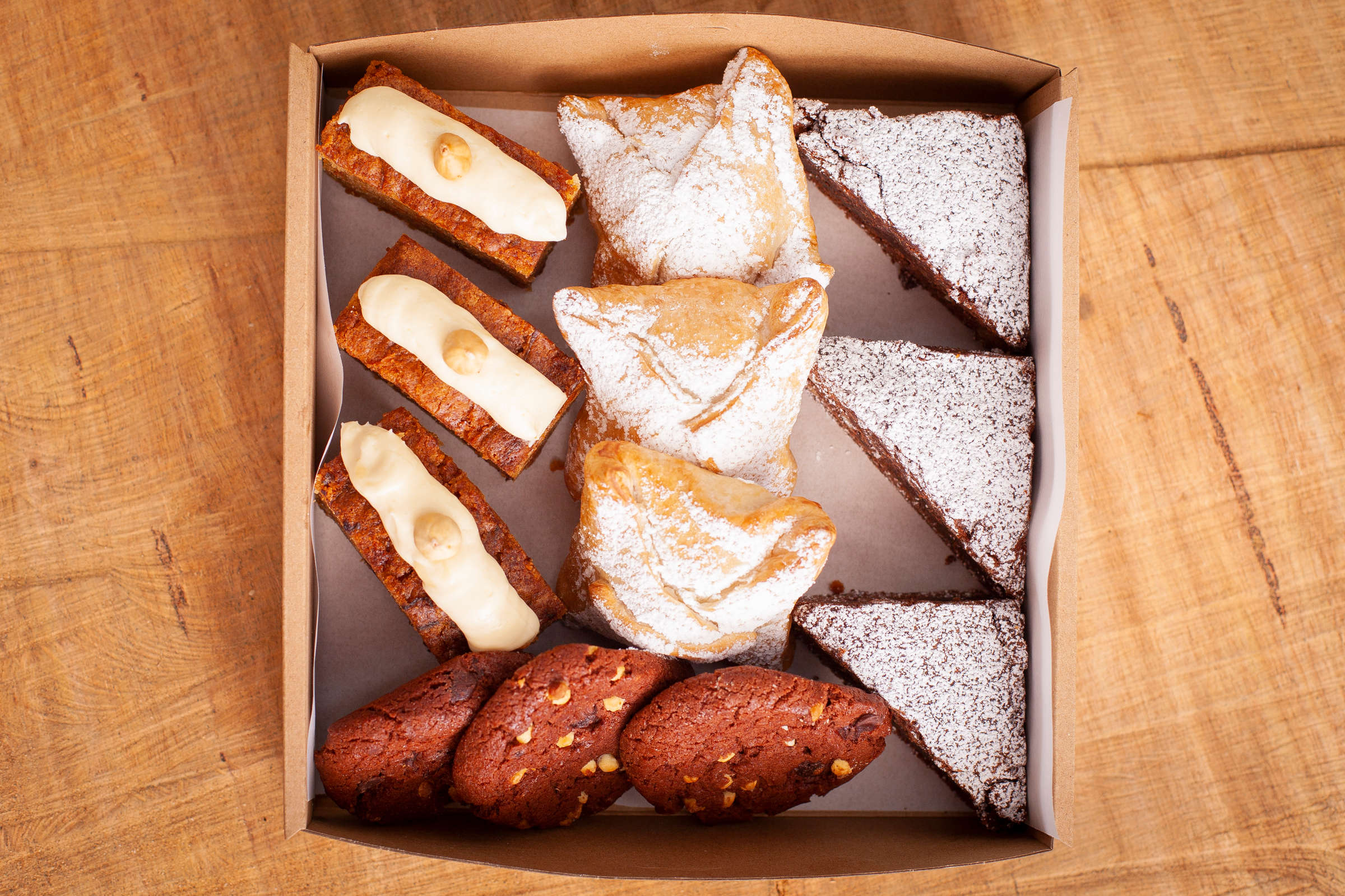 Small sweet selection box containing 12 items including chocolate brownie, Danish pastries, Carrot cake with cream cheese icing, Cookies. Credit: Richard Jupe.